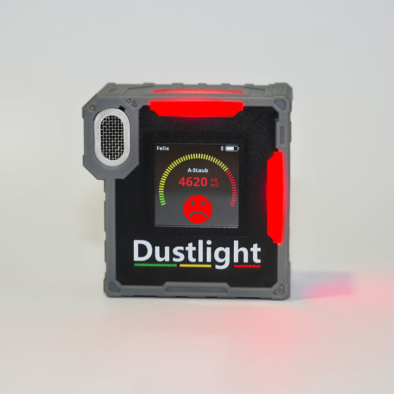 Dustlight A-Staub Messgerät zur Überwachung der Luftqualität am Arbeitsplatz, robust und tragbar für den industriellen Einsatz. Grüne LED deutet auf eine Staubexposition unter dem Schwellwert hin.
