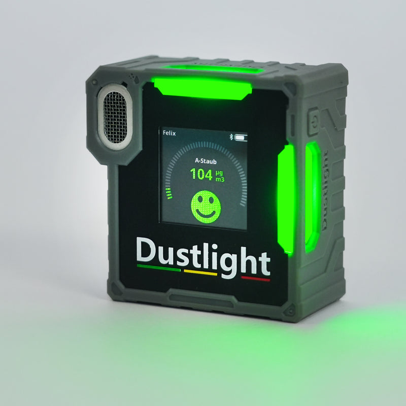 Dustlight A-Staub Messgerät zur Überwachung der Luftqualität am Arbeitsplatz, robust und tragbar für den industriellen Einsatz. Grüne LED deutet auf eine Staubexposition unter dem Schwellwert hin.